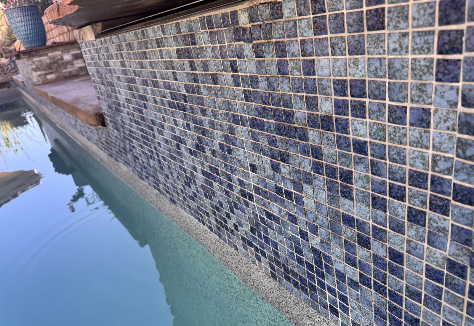Calcium removal on a blue mosaic spillway, after