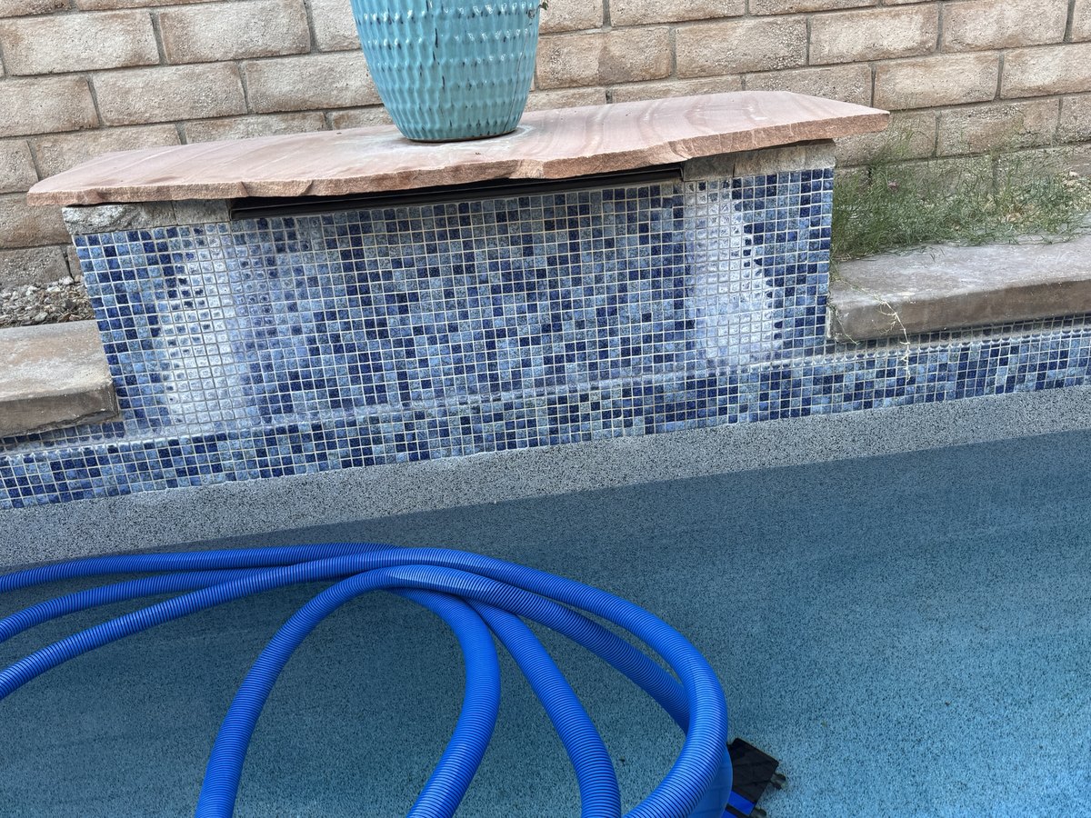Calcium removal on a blue mosaic spillway, before